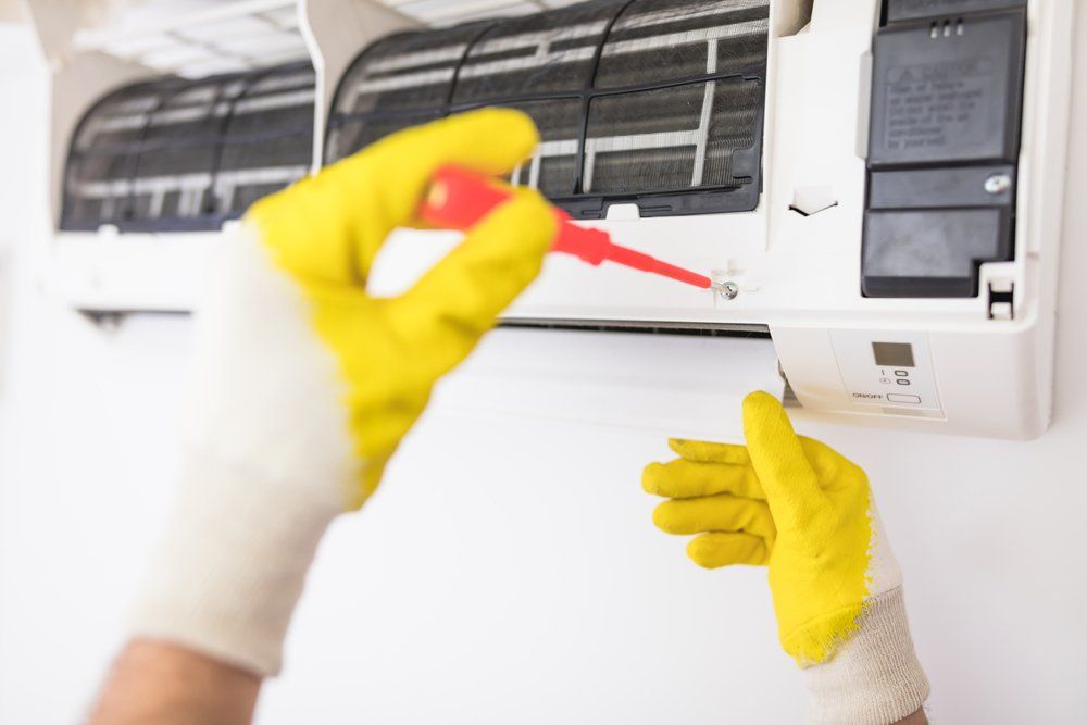 A Person is Fixing an Air Conditioner With a Screwdriver, Enterprise Air That's Cool in Avondale, QLD