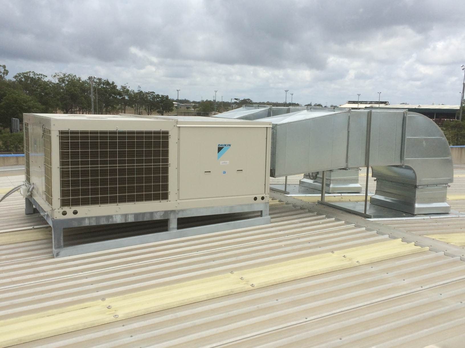 A large air conditioner is sitting on top of a roof.